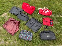 All nine travel bags laid out on grass