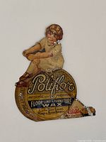 Full view of die-cut tin sign showing girl and wax tin graphic