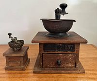 Large and miniature coffee grinders side by side
