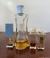 Front view of four perfume bottles showing labels and caps