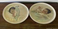 Both oval framed prints side by side