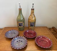 Full lot showing two Olivia pattern bottles and four matching snack plates