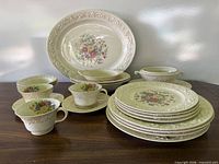 entire dinnerware set grouped on table showing platter, bowls, plates, cups