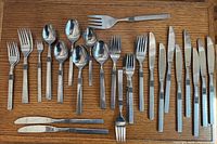 Overview of entire 47-piece flatware set arranged on wood surface