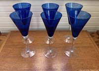 Front view of six cobalt blue fluted champagne glasses