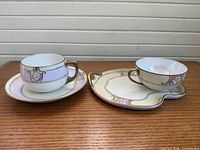 Two Meito China teacups with their matching saucers displayed on tabletop