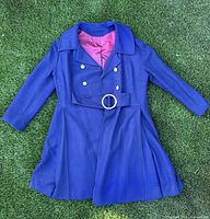 Front view of royal blue wool double-breasted coat laid flat showing belt, buttons, lapels and lining