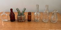 All eight vintage glass bottles lined up on table
