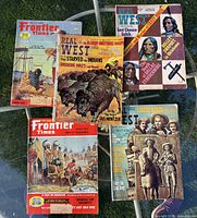 Overview of all five magazine covers laid out on glass table