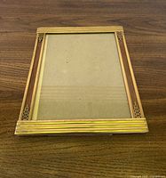 Front view of rectangular metal Art Deco frame with glass and backing