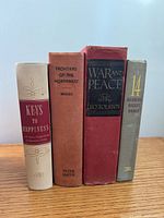 Spine view of four hardcover books standing in a row