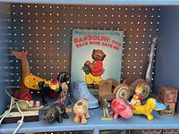Full shelf view showing book, multiple wooden pull toys, figurines, loose wooden wheels and blocks