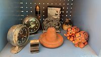 Group shot of all items: clocks, rocket, figurines, case, sombrero, metal block