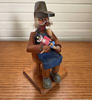 Front angled view of seated wooden smoker figurine