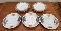 Two stacks of floral-band plates and three cobalt plates laid out