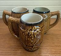 Three brown ceramic barrel mugs grouped front angle