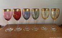 Front view of six multicolour gold-banded Cellini crystal wine glasses