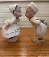 Side view of Dutch boy and girl figurines posed to kiss