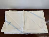 Stacked white linen napkins tied with blue ribbon