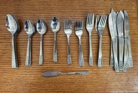 Entire flatware set laid out showing all pieces and pattern