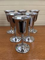 six silver-tone metal goblets front view