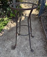Full view of wrought iron plant stand showing top ring and legs