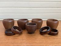Front view of all five cups and four napkin rings on wood surface