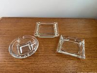 All three ashtrays top view on wood surface