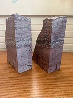 Front angled view of both petrified wood bookends showing polished faces and striations