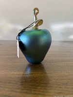Front view of iridescent glass apple with gold stem