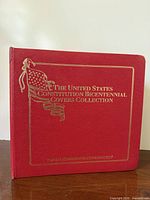 Front of red binder with gold embossed title and flag logo
