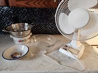 Group shot showing fan, colander, stoneware bowl, glass bowl, enamelware bowl
