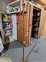 Full view of brass floor candelabra with five red taper candles showing overall structure and height