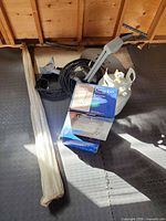 Lot overview showing boxed carriage light, satellite dish, propane cylinder, mounting pole and coaxial cable