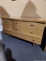 Front view of light wood six-drawer dresser on tapered legs