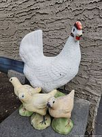 Front view of all four concrete chicken statues