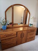 Front view showing dresser, six drawers, center cabinet, and attached tri-fold mirror