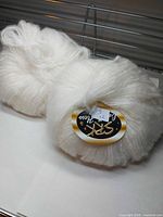 Two white yarn skeins with SRK front labels visible
