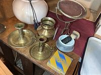 Overview showing candlesticks, vase, shaving mug with brush, brass mirror stand, sealed 4711 box