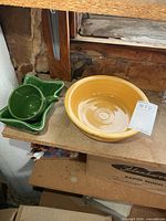 Overall view of yellow Fiesta bowl, green UPCO dish, green teacup on shelf