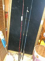 Full view of three fishing rods standing upright