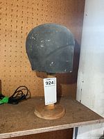 Front view of vintage hat display stand on wood base