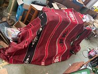 Full view of red wool blanket draped over items