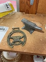 Lead anvil and brass plaque side by side
