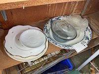 Group view showing platter, plates stack, Pyrex casserole with lid, and candy dish