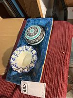 Overall shot of three pottery pieces: blue tray, ruffled bowl, lidded dish