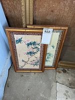 Both framed prints leaning against wall