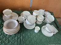 All porcelain pieces grouped, showing mix of cups, saucers, plates, gold trim