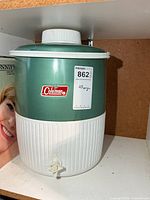 Front view of green and white Coleman jug showing logo, spigot and lid