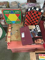 Overall lot showing Clue box, San Loo board, red-black checkerboard, wooden Chinese Checkers board, marbles